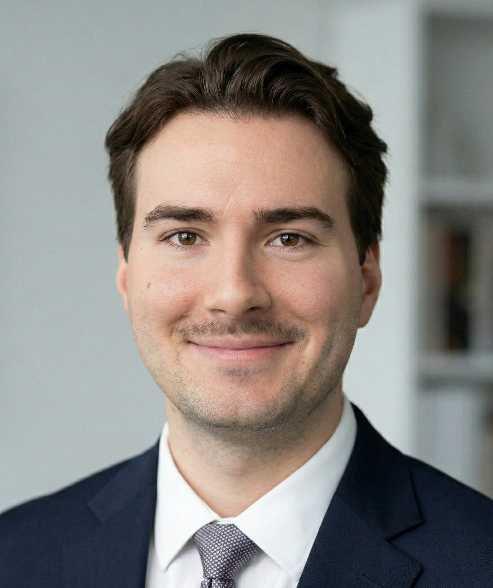 Will Kitching wearing a navy suit and tie